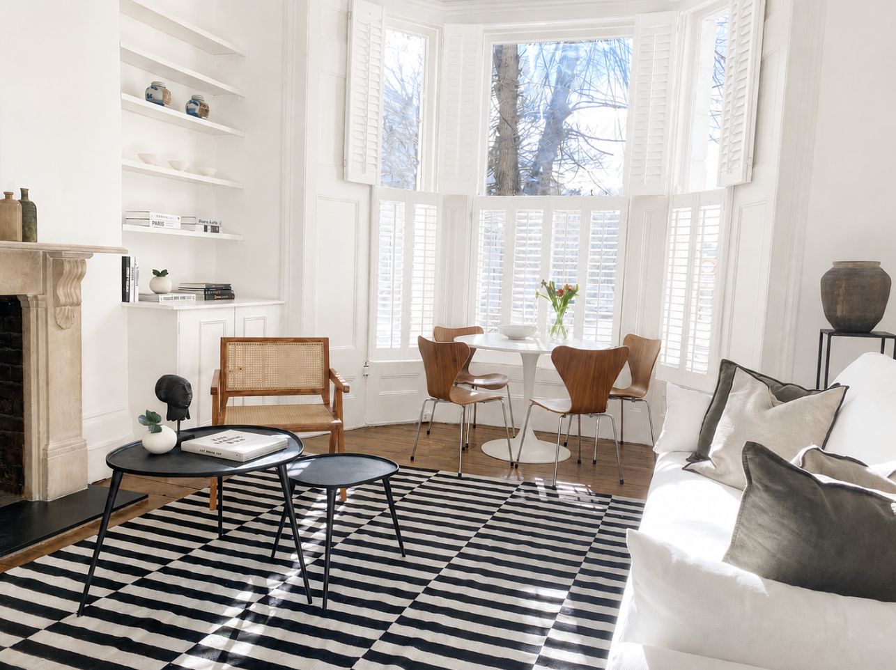 Bay window sitting room with monochrome striped rug and Series 7 chairs